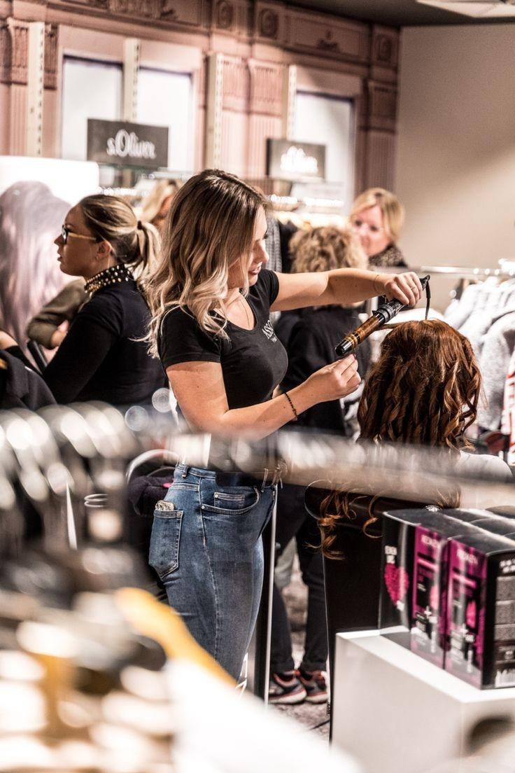 Hairstylist curling client's hair in salon